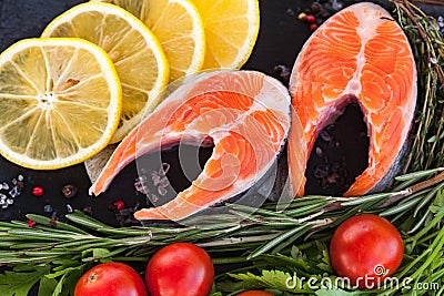 salmon steakes with greenery, lemon and cherry tomatoes Stock Photo