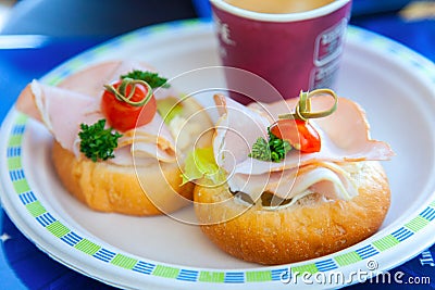Two sandwiches with ham, parsley and cherry lying on a plate in a cafe Stock Photo