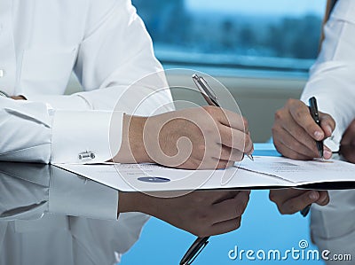 Two Saudi Businessmen Hands Signing A Ducument Stock Photo