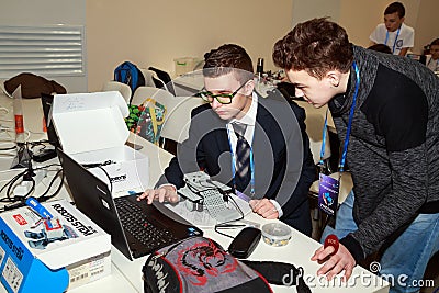Two schoolboys programming the robot at robotics competitions. Editorial Stock Photo