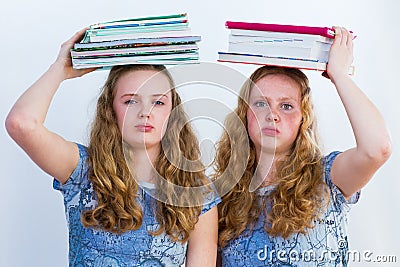 Two schoolgirls with textbooks on their heads Stock Photo