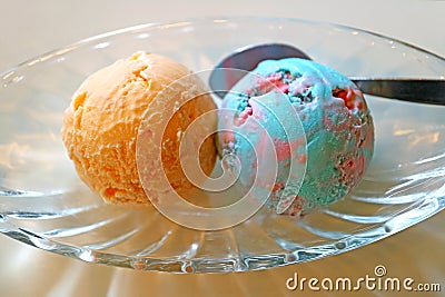 Two Scoops of Orange Ice Cream and Bubble Gum Ice cream Served in a Glass Bowl Stock Photo