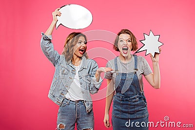 Two screaming women friends holding speech bubbles. Stock Photo