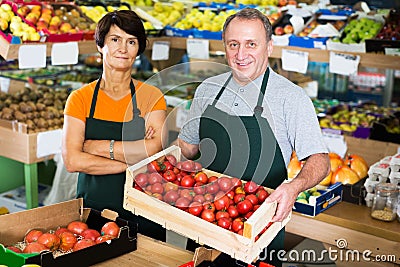 Two sellers are offering red tomatos Stock Photo