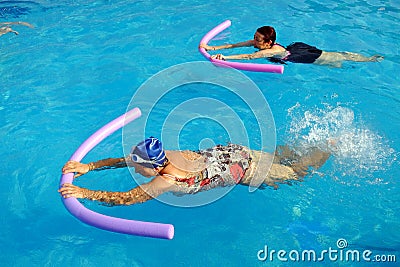 Two senior women doing swimming exercise in pool. Stock Photo