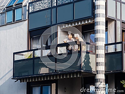 Two senior women on the large balcony breathing fresh air in French architecture Editorial Stock Photo