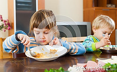 Two serious children eating food Stock Photo