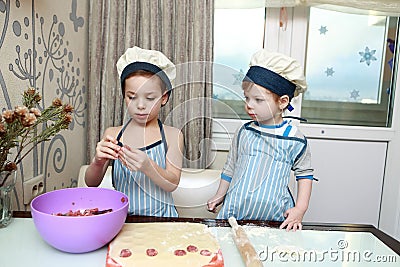 Two serious children mold dumplings Stock Photo