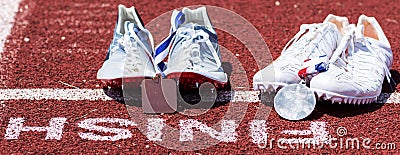 Two sets af running spikes at finish line with medals Stock Photo