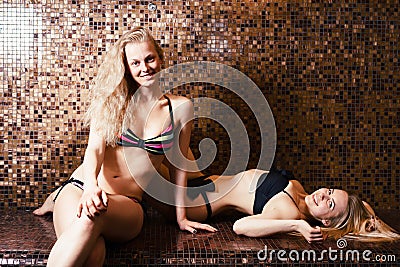 Two sexy young girls blonde swimsuits steamed in the sauna. Turkish bath Hamam. healthy lifestyle concept. spa treatments Stock Photo