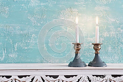 Two shabbat candlesticks with burning candles over wooden table Stock Photo