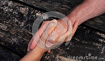 Two shaking hands. Love and friendship concept. Aid for old people. Trust and security for elderly. Caucasian human hands on black Stock Photo