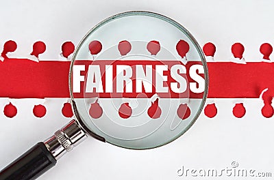 Between two sheets from a notebook on a red stripe with the inscription - Fairness, there is a magnifying glass Stock Photo
