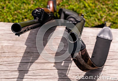 Two shotguns leaned up against a wooden bench Stock Photo