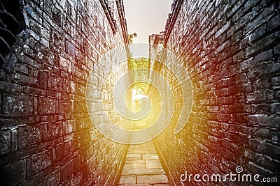 Two sided brick wall with a small pathway, If go straight forward, you will find the light of success Stock Photo