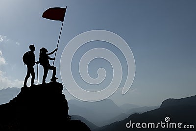 Silhouette climbers with flag on mountain Stock Photo