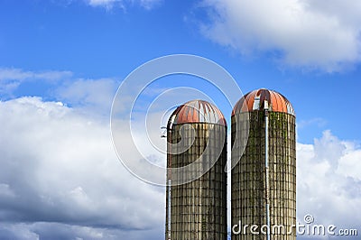 Two Silos against a partically cloudy sky Stock Photo