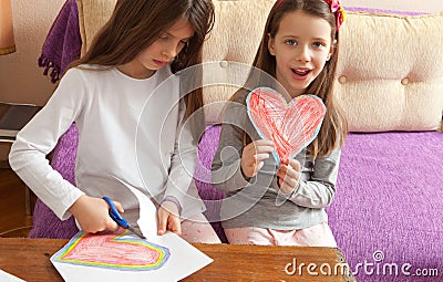 Two Sisters are Drawing Colorful Hearts Stock Photo