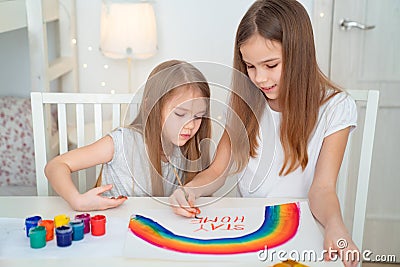 Two sisters write stay at home. flashmob. rainbow. Stock Photo