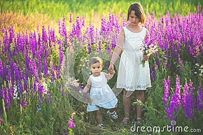 Two sisters holding hands in the flower chain Stock Photo