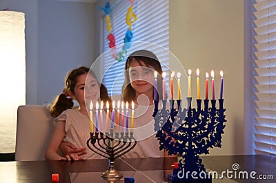 Sisters looking at candelabrum on the eight day of Hanukkah Jewish holiday festival Stock Photo