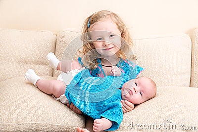 Two sisters. Older sister kid hugging his newborn little sister. Stock Photo