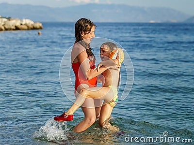 Two sisters playing games and swimming in the sea Stock Photo