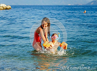 Two sisters playing games and swimming in the sea Stock Photo