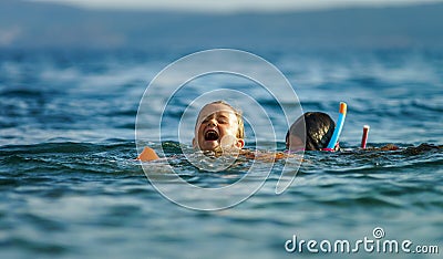 Two sisters playing games and swimming in the sea Stock Photo