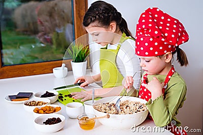 Two sisters preparing granola together Stock Photo