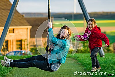 Two sisters: preschooler and teenage - playing on playground Stock Photo