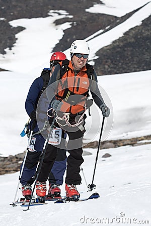 Two ski mountaineers climb on mountain on skis strapped to climbing skins Editorial Stock Photo