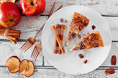 Two slices of autumn caramel apple pecan cheesecake, top view table scene over white wood Stock Photo