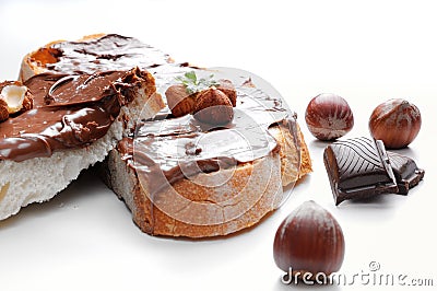 Two slices of bread with chocolate cream and hazelnuts front Stock Photo