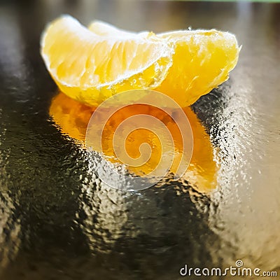 two slices of tangerine on a golden background fruit reflection orange background Stock Photo