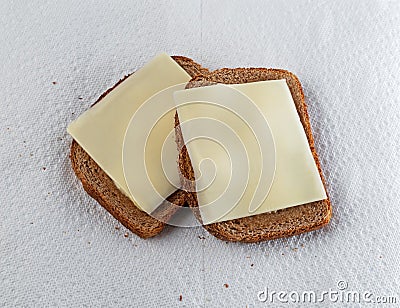 Two slices of wheat bread with margarine and cheese on paper towels Stock Photo