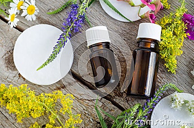 Two small bottles with essential oil tincture, infusion and cotton pad. Aromatherapy and natural skin care concept. Stock Photo