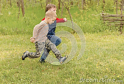 Two small boys running across a field Stock Photo