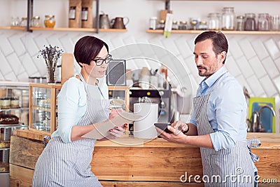 Two small business owners in aprons standing in cafe Stock Photo