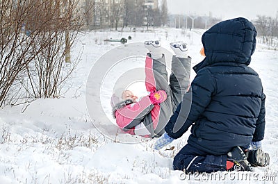 Two small children frolicking in the snow Stock Photo