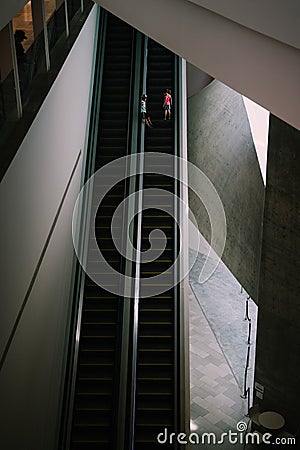 Two small children going up the escalator alone. Stock Photo