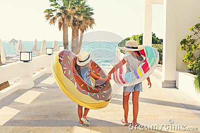 Two small girls with inflatable toys on the beach Stock Photo