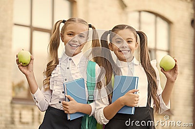 two small girls ready to study. do homework together. sisters at lunch break with apple. healthy and happy childhood Stock Photo