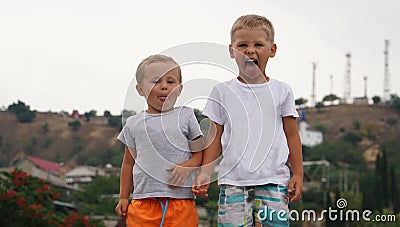 Two small kids playing together outdoors standing on coast of the sea Stock Photo