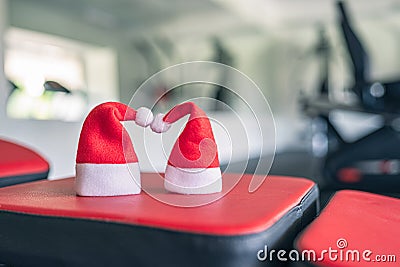 Two small santa hat in the gym opposite the equipment and row of jogging simulators. Symbol and concept of discount offer on Chris Stock Photo