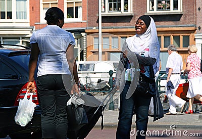 Two smiling African black women speaking on the street Editorial Stock Photo