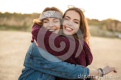 Two smiling female friends hugging each other Stock Photo