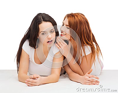 Two smiling girls whispering gossip Stock Photo