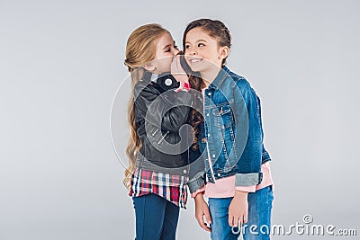 Two smiling little girls whispering secrets Stock Photo