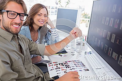 Two smiling photo editors working with contact sheets Stock Photo